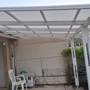 פרגולת עץ לבנה עם קירוי סנטף בחצר בית