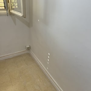 קיר עם שקע חשמל ורצפת אריחים