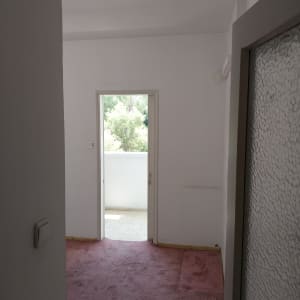 חדר עם קירות לבנים ושטיח ורוד