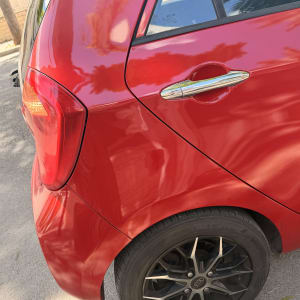 חלק אחורי של רכב אדום עם פנס וגלגל