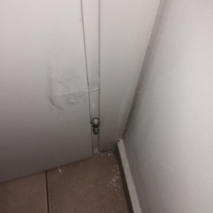 דלת לבנה עם ציר על רצפת אריחים