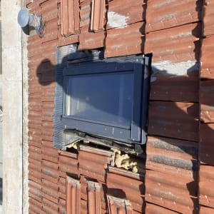 חלון בגג רעפים אדומים עם תיקונים