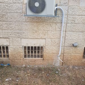 יחידת מיזוג אוויר מותקנת על קיר אבן חיצוני