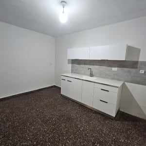 מטבח נקי עם ארונות לבנים וברז כיור