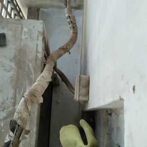 צינור עטוף בבד ליד קיר עם כתמי טיח