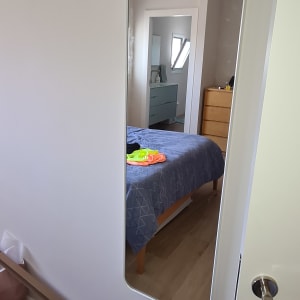 מראה על קיר עם סרט מדידה על שידה