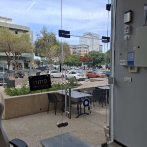 דלת זכוכית שקופה עם נוף חיצוני של רחוב ועצים