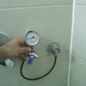 מד לחץ מים מחובר לברז בחדר אמבטיה