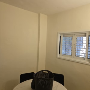 קיר צבוע וחלון בחדר עם שולחן עגול