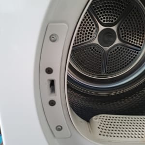 תוף מכונת כביסה עם דלת פתוחה וברגים