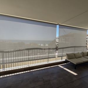 מרפסת עם סוככים נגללים ונוף לים