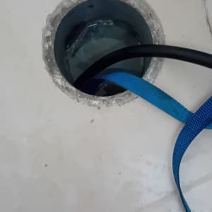 צינור כחול ושחור בתוך פתח ניקוז ברצפה