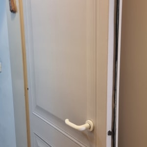 דלת עם ידית לבנה מותקנת במסגרת