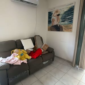 סלון עם מזגן על הקיר וספה עם צעצועים
