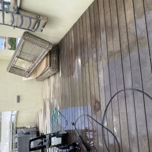 מכונת שטיפה על רצפת עץ רטובה במרפסת