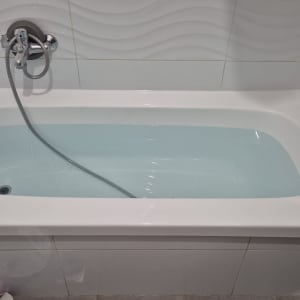 אמבטיה עם מים, ברז ומקלחת יד