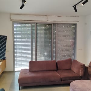 חלונות עם תריסים אפורים סגורים למחצה