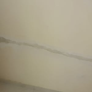 קיר עם סימני תיקון ושקע חשמלי