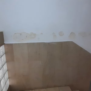 קיר עם סימני רטיבות ותיקונים