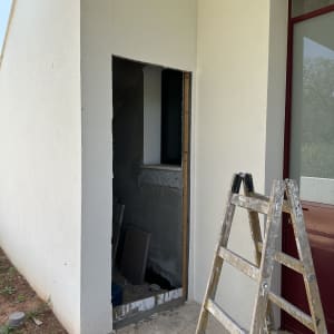 פתח דלת בבנייה עם סולם עץ לידו