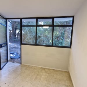 חלון ודלת אלומיניום בחדר ריק עם סולם