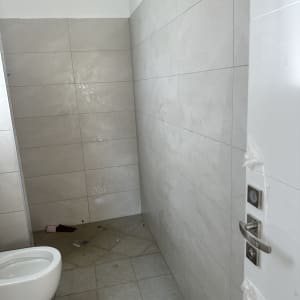 שירותים עם לכלוך על הרצפה ודלת פתוחה