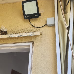 פנס חיצוני מותקן על קיר עם חוטי חשמל