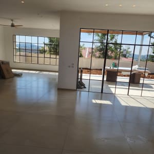 חלל דירה מרווח עם ריצוף גרניט פורצלן וחלונות ויטרינה נקיים