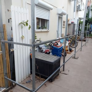 מסגרת מתכת ליד גדר עץ לבנה בגינה