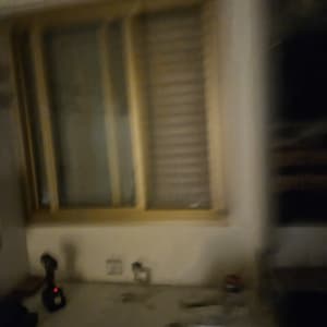 חלון עם תריסים וכלים על השולחן