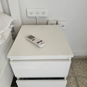 שקעי חשמל על הקיר ליד שידה לבנה