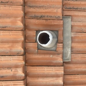 רעפים כתומים עם צינור בולט מהגג