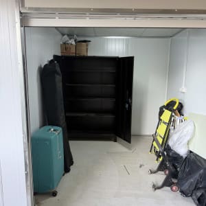 חדר עם ארון פתוח, מזוודה, וכלי עבודה שונים