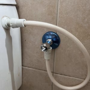 צינור מים מחובר לשסתום על קיר אריחים