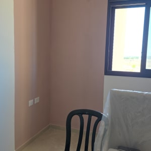 חדר צבוע בצבע ורוד עם כיסא שחור