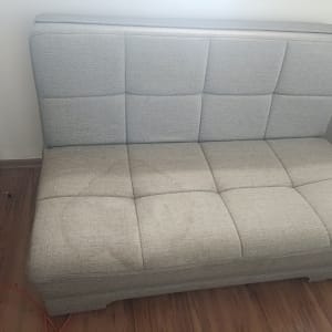 ספה אפורה עם כתם על הרצפה