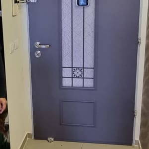 אדם עומד ליד דלת מצופה עם עיצוב זכוכית