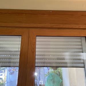 תריסים לבנים במסגרת עץ חומה