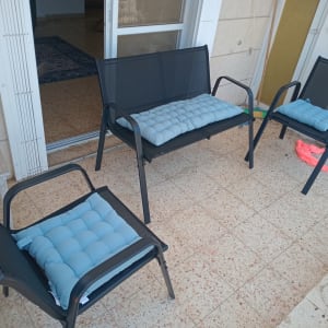 כיסאות מרפסת עם כריות כחולות על רצפת אריחים