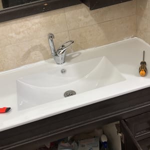 כיור עם ברז, מברג וסכין יפנית על השיש