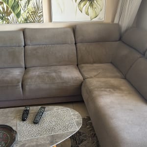 ספה אפורה בסלון עם שלט רחוק על שולחן