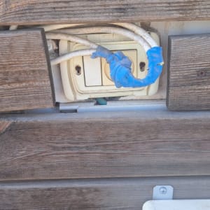 שקע חשמל עם חוטים עטופים בסרט כחול