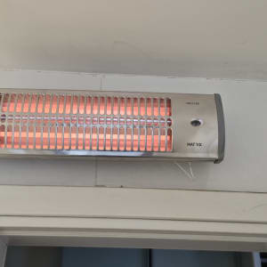 תנור חימום מותקן על קיר עם חיבור לחשמל