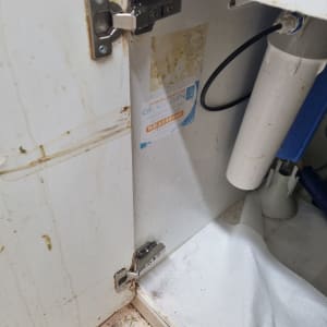 תמונה של ארון מטבח עם צינור ומסנן מים