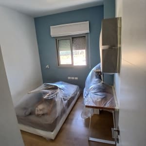 חדר עם רהיטים מכוסים בניילון, קיר כחול