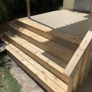 מדרגות עץ חדשות בגינה עם אור שמש