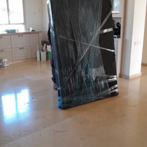 רהיט עטוף בניילון מוכן להובלה בחדר ריק