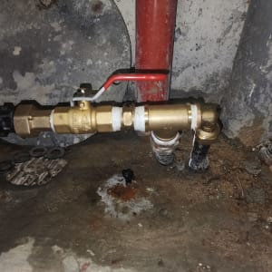 שסתום פליז עם ידית אדומה בצנרת מים