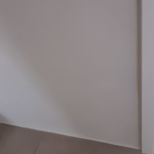 קיר צבוע בלבן עם צללים על הרצפה