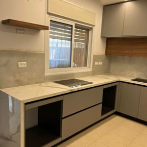 מטבח בשיפוץ עם ארונות חדשים ומשטח עבודה